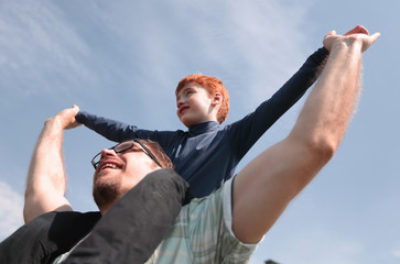 happy father has a little son on his shoulders