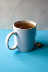 mug with tea in a bag on a blue table