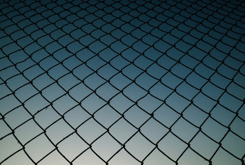 Old metal mesh against the evening sky. Abstract background