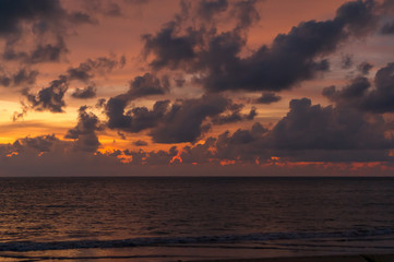 Obraz na płótnie Canvas Colorful ocean beach sunset with a few clouds