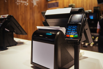 Point of sell terminal with touchless technology and cashbox on background