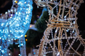 Christmas led illuminated deer sculpture on new year tree background