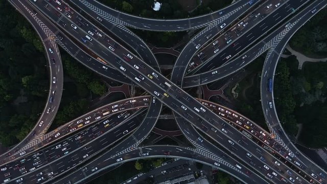 Overhead aerial drone shot of massive intersection at dusk, infrastructure and transportation in Shanghai, China