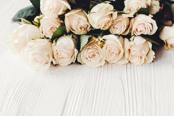 Floral greeting card mockup. White roses on wooden background, space for text. Wedding invitation or happy mother day or valentines concept. Bouquet of white flowers
