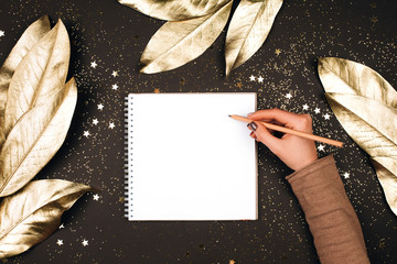 Goal lift for New Year. Holiday decorations and notebook with wish list on dark table, flat lay...