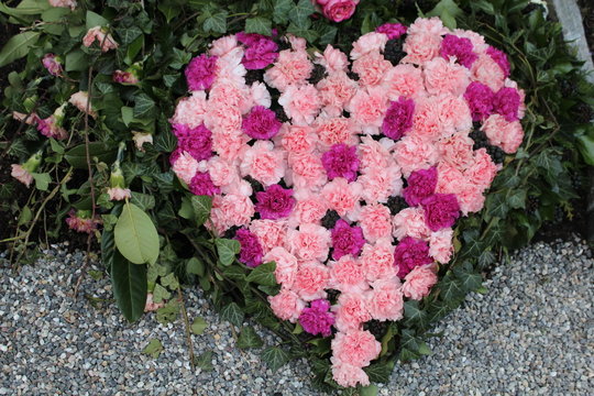 Herz aus Rosen vor einem Grab