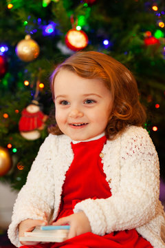 Beautiful little child near Christmas tree.
