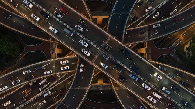 Overhead drone shot of cars driving over elevated highway and busy interchange in Shanghai, China