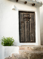 Fototapeta na wymiar Typical residence with white walls and wood door of the fishing village Binibeca Menorca Spain