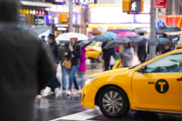 Blurred picture of a yellow cab speeds through Times Square, the busy tourist intersection of neon...