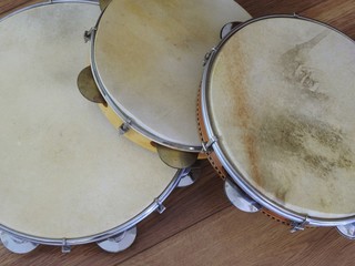 Obraz premium Close-up of three pandeiros (tambourines), a Brazilian musical percussion instrument, on a wooden surface. It is widely used to accompany samba and choro, two popular Brazilian rhythms.