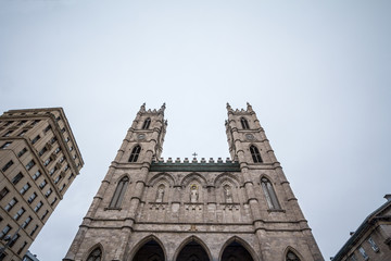 Fototapeta premium Notre Dame Basilica Skyline in the Old Montreal, with its main facade and its iconic towers. The basilica is the main cathedral of Montreal, Quebec, Canada, and a touristic landmark
