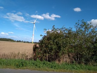 Electric turbine windmill with fairy tale landscape and cloudscape