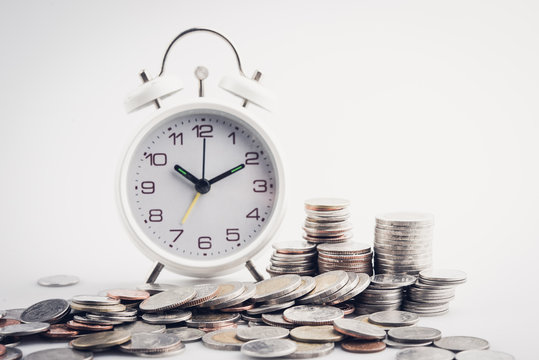 clock and rows of coins for time of finance and business concept