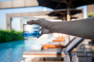 A glass of clean mineral water in woman's hands.