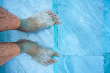 Feet in the water at the swimming pool.