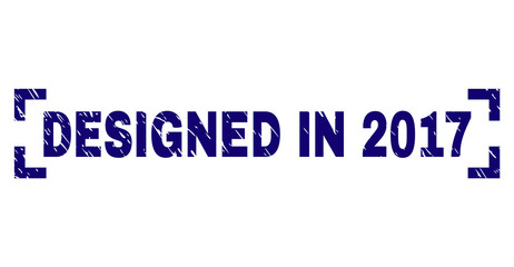 DESIGNED IN 2017 text seal stamp with distress style. Text tag is placed between corners. Blue vector rubber print of DESIGNED IN 2017 with scratched texture.