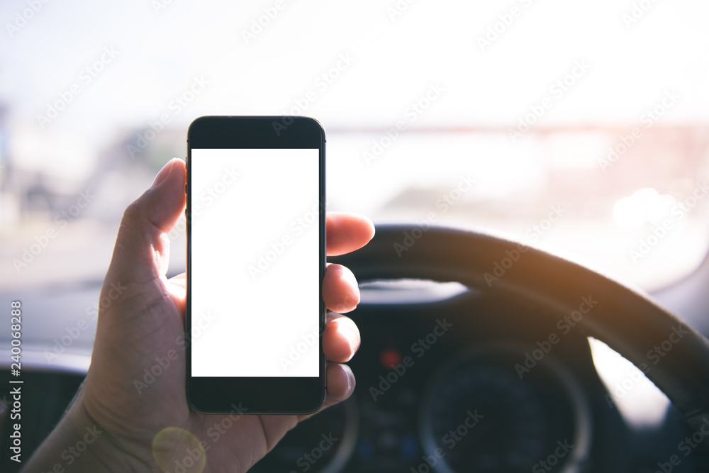 Aufkleber Hand using blank white screen mobile smartphone inside a car in sunny day, copy space for your app or product display,