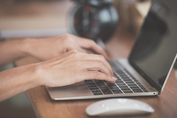 woman using laptop, searching web, browsing information, having workplace at coffee shop.