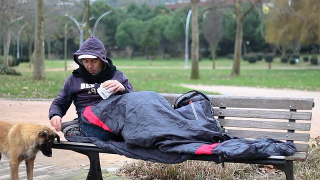 Homeless Man Eats A Snack And Shares His Food With The Dog