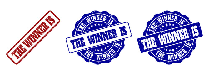 Obraz premium THE WINNER IS grunge stamp seals in red and blue colors. Vector THE WINNER IS signs with grunge style. Graphic elements are rounded rectangles, rosettes, circles and text captions.