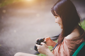 Travel concept - Woman traveler with enjoying outdoor photography, Happy with the camera in the holidays.