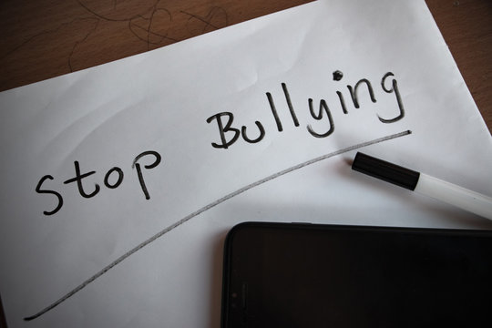 Stop bullying text write on white paper. Bullying is unwanted and aggressive behavior. It considered a social problem.