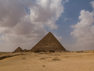 Fototapeta na wymiar Pyramids of Egypt with a blue sky and white fluffy clouds