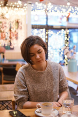 Woman drinking coffee in a cafe.