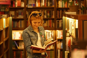 caucasian woman with book in bookstore