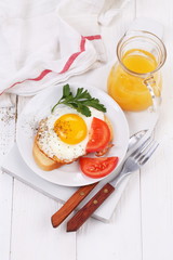 fried eggs on a piece of white bread and orange juice