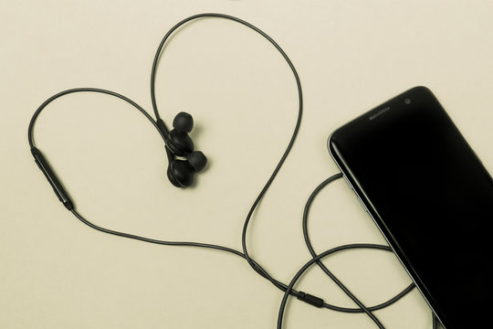 mobile phones on a light background and headphones in the form of a heart