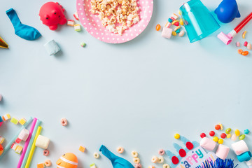 Holiday frame or background with colorful balloon, gift, confetti, silver star, carnival cap and streamer. Flat lay style. Birthday or party greeting card with copy space.