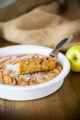 sweet apple pie in ceramic form on a wooden