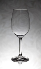 Glass wine glass stands on a blurred background