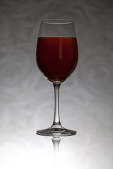 Glass goblet with wine stands against blurred background