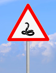 Warning road sign against blue sky. Animals on the road (snake). 