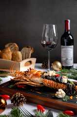 Luxury dinner menu grilled lamb, pasta lobster during Christmas and New year. Decrated with festive elements, wine, bred, red burry. Beautiful classic background with space.