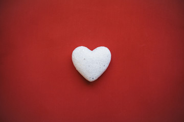 White heart on a red background. Concept for Valentine's Day or Women's Day or the topic of health, life, donation and help. In minimal style.