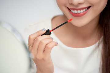 Young beautiful woman professional beauty vlogger or blogger applying lipstick cream to her mouth, doing a make up tutorial