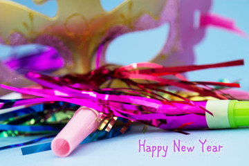 happy new year with masks, streamers and blowers