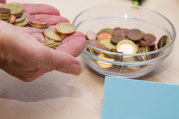 hands introducing coins in the glass jar, concept of pension and retirement