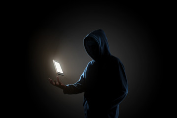 White smartphone floating above of hacker's hand in dark background. Finance, business, e-commerce or cyber crime concept