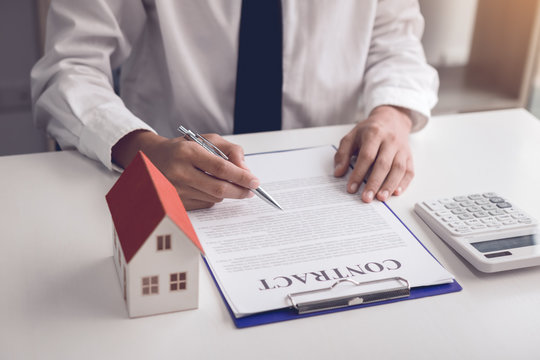 New home buyers are signing a home purchase contract at the agent's desk.