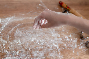 Fototapeta premium Christmas cookies preparation. Cookies cutter, dough for cookies and rolling pin on the kitchen table. Homemade treats. Selective focus.