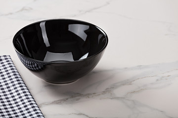 Black soup bowl on marble countertop.