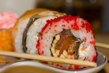 Sushi rolls with salmon, eel, cream cheese Philadelphia, caviar tobica and food sticks on the plate