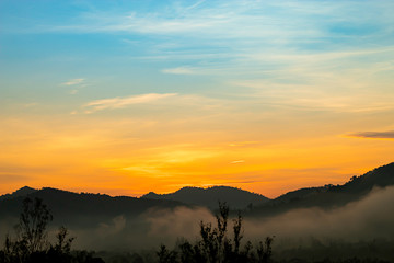Fototapeta na wymiar The morning sun light behind the mountains and the mist.