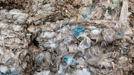 Background texture of used plastic bags and packaging stored at plant for sorting and recycling household waste