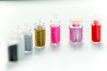 various colorful nail varnish in containers on a table
